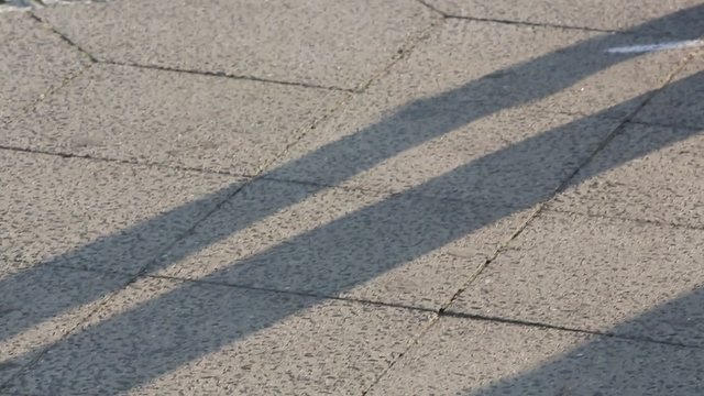 Cropped image of two dancers' feet moving on the sidewalk