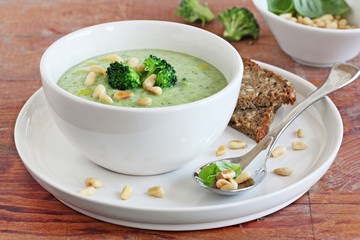 Broccoli-potato soup with pine nuts and broccoli topping 
