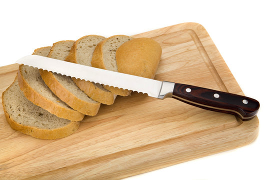 knife and bread on cuttingboard isolated on white background
