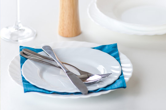 plates and cutlery with blue napkin dining composition