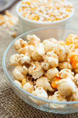 A bowl of popcorn on a wooden table, caramel popcorn
