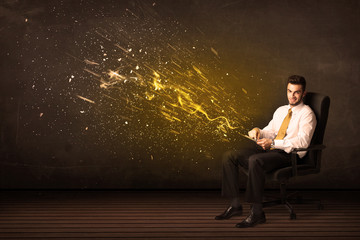 Businessman with tablet and energy explosion on background