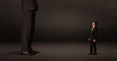Fototapeta premium Huge man with small businessman standing at front concept