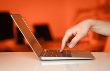 Businessman pressing modern laptop computer on colorful backgrou