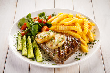 Grilled steak, French fries and vegetables