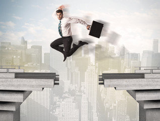 Energetic business man jumping over a bridge with gap