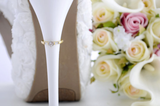 Wedding ring on beautiful white stiletto shoe heel.