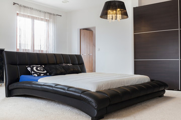 Huge leather bed in bedroom