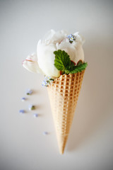 Ice cream's immitation in waffle cone decorated herbs. Peonies.