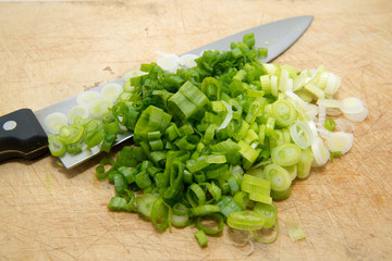 scallions on cutting board with knife