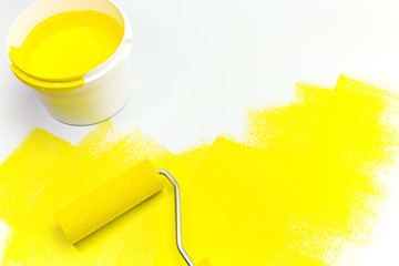 yellow paint can with paint roller