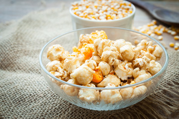 A bowl of popcorn on a wooden table, caramel popcorn