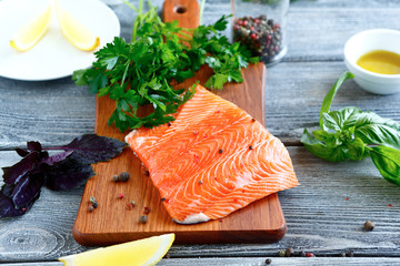 Salmon fillet with parsley, basil and lemon on a cutting board