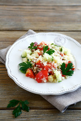 Salad with cooked couscous and fresh vegetables on a plate