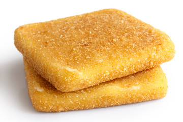 Two square golden fried cheeses on white.