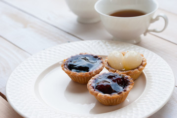 Fruit tart with tea on wooden board