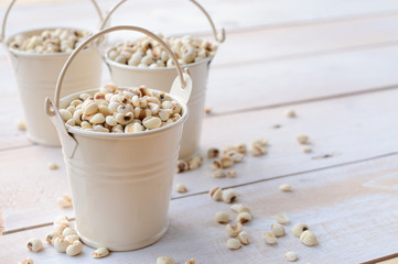 Job's tears in white bucket on wooden board, healthy food
