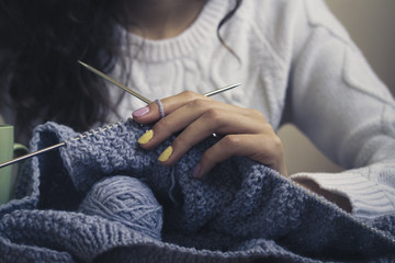 Blue knitting in female hands closeup