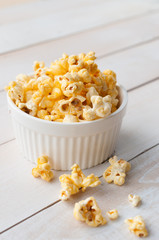 Popcorn in bowl over wooden background