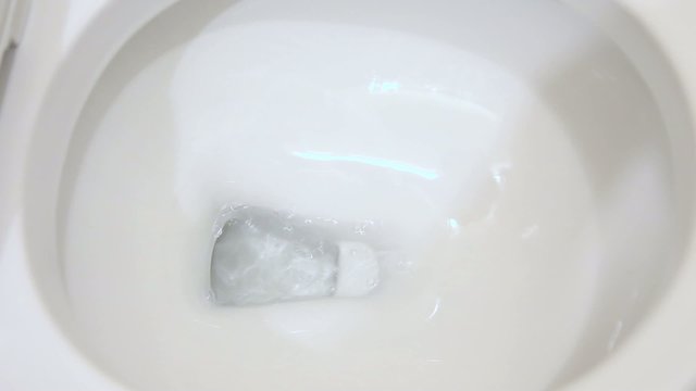 Toilet being flushed in bathroom