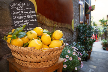 Wicker basket full of lemons on the italian street od Corniglia