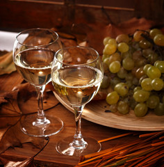 Fototapeta premium Two glasses of white wine with grapes