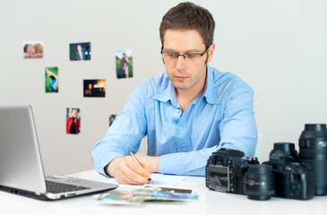 Fototapeta na wymiar Photographer selecting photos on his computer.