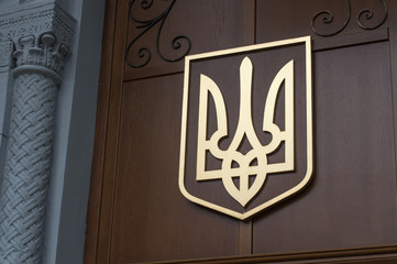 Coat of arms of Ukraine on wall.