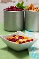 Bowl with cornflakes in front of two aluminum cups
