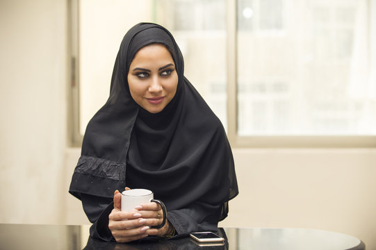 Arabian businesswoman drinking coffee in office