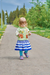 Naklejka premium Little girl walks in the park