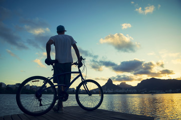 Fototapeta na wymiar Sunset Silhouette Man with Bicycle Lagoa Rio de Janeiro Brazil