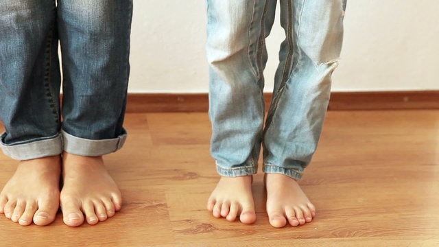 Mother and son fooling around stepping on feet each other