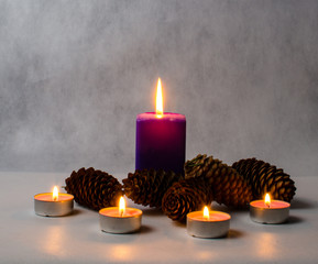candles of different sizes and colors, and cones on a bright bac