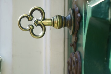 Brass key in a green old door
