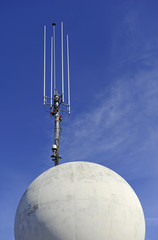 Antenna on skyscraper with blue sky
