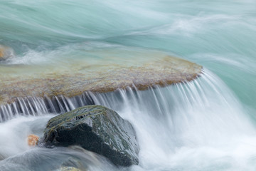 Wasser fließt über Gebirgsstein