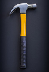 aerial view claw hammer with yellow and rubber handle on black b