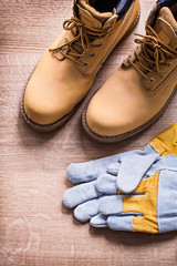 protective gloves and working boots on wooden board construction