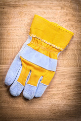 protective work glove on wooden board construction concept