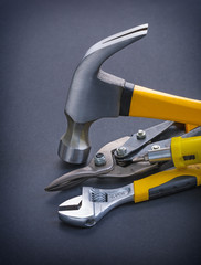 screwdriver claw hammer adjustable wrench with yellow handles on