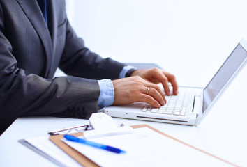 Businessman sitting in office, working with laptop computer