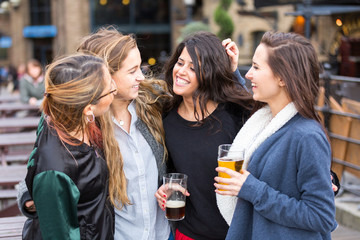 Group of women enjoying a beer at pub in London.