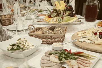 Decorated table with snacks, fruits, salads, meats