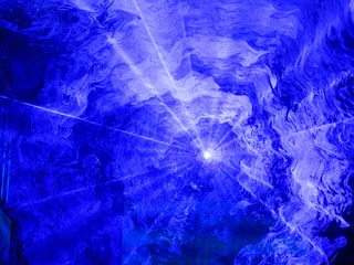 Crédence de cuisine en verre imprimé Lumière et ombre Projecteur bleu brillant à travers la fumée