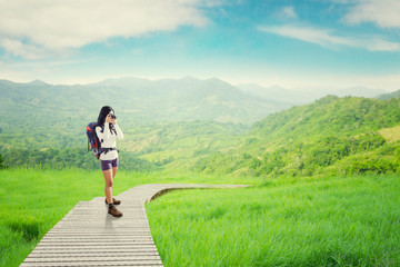 Backpacker taking picture on the wooden path