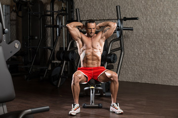 Fototapeta na wymiar Bodybuilder Exercising Triceps With Barbell