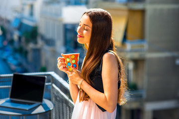 Woman with colorful coffee cup on the balcony