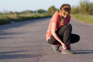 Girl tying shoelaces doing jogging