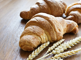 Freshly baked croissants on rustic background with copyspace.